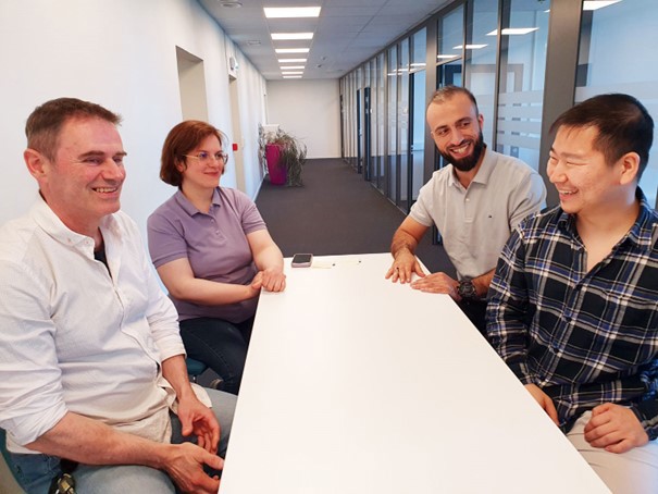 four people sitting at a table, office environment