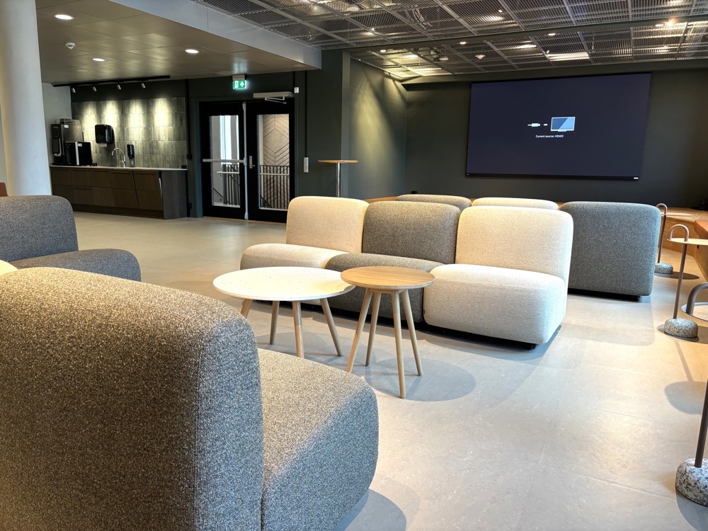 stort møterom med lounge-møbler, scene og kjøkken