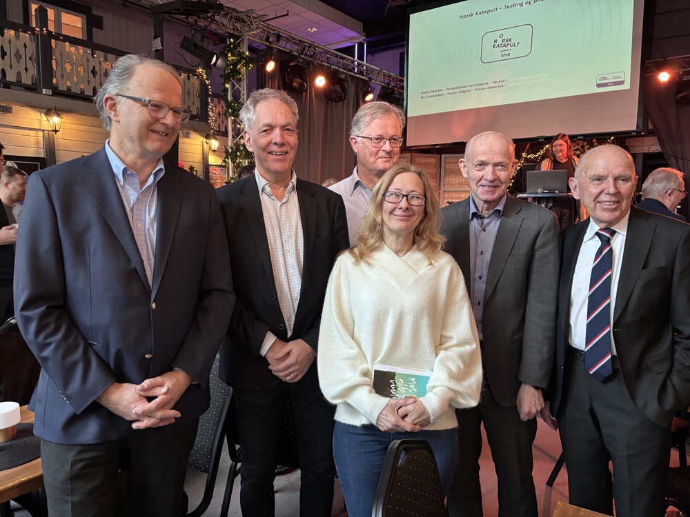 gruppebilde, arrangementslokale, scene i bakgrunnen med monitor i taket