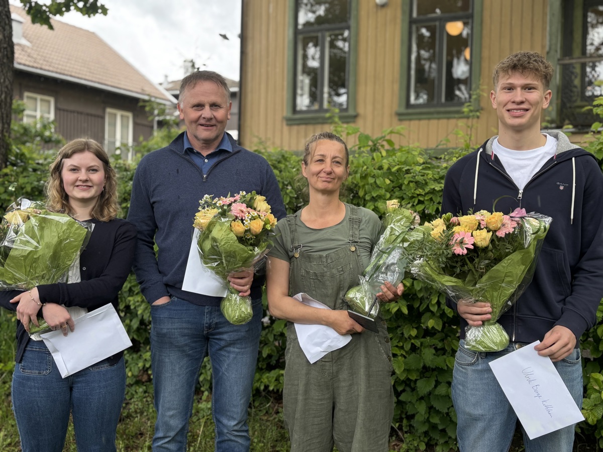 fire personer står på rad, poserer, alle med en blomsterbukett hver og hvite konvolutter