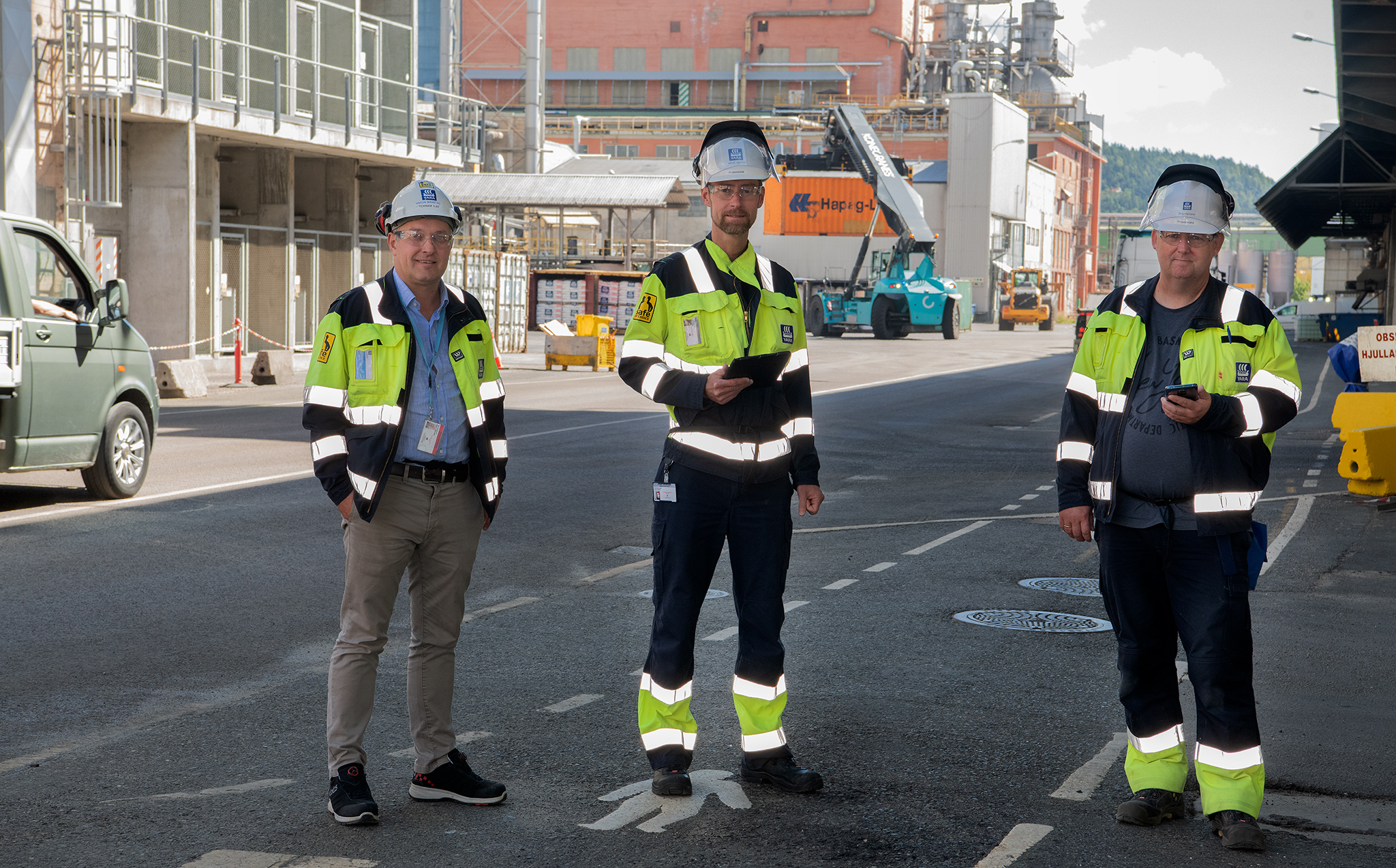 three men out in the street in industrial park, measuring 5G coverage