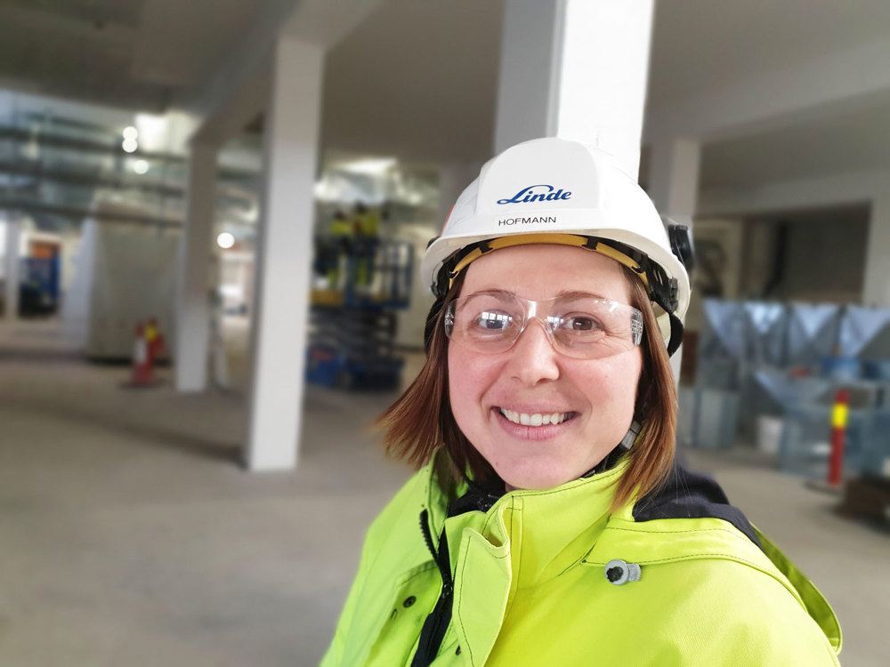 portrait of woman, yellow jacket, white helmet, goggles, industry hall
