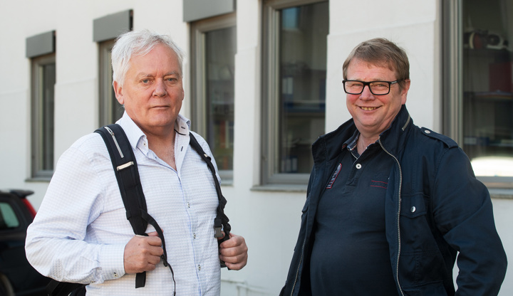 to menn poserer står ved siden av hverandre