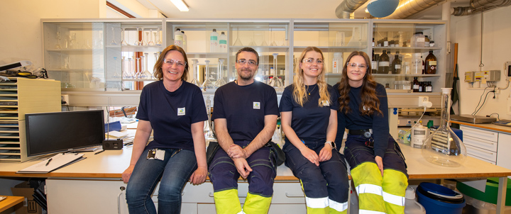 four persons sitting on a table in a laboratory